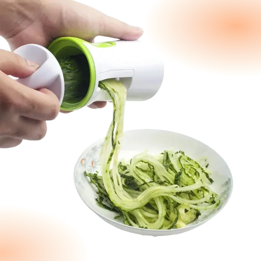 Hand using a spiralizer to create zucchini noodles on a white plate.